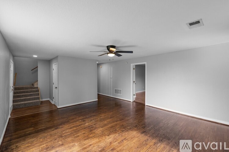 A room with wooden floors and a ceiling fan.