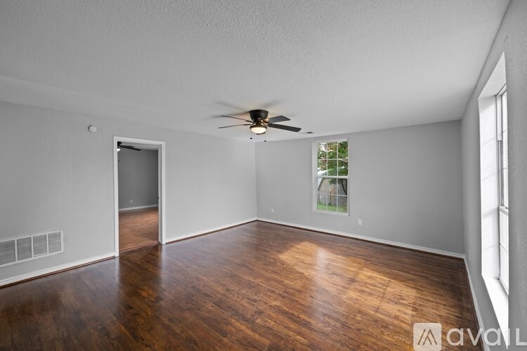 A room with wooden floors and a ceiling fan.