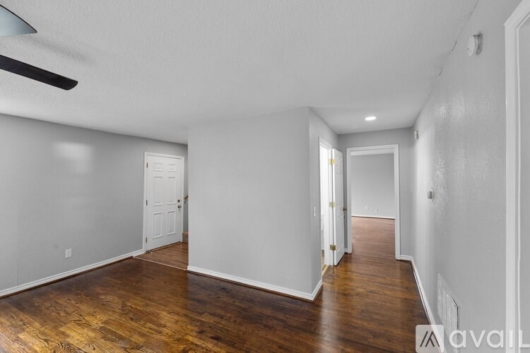 A spacious room with wooden floors and white walls.