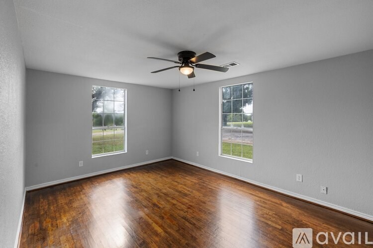 A room with wooden floors and a ceiling fan.
