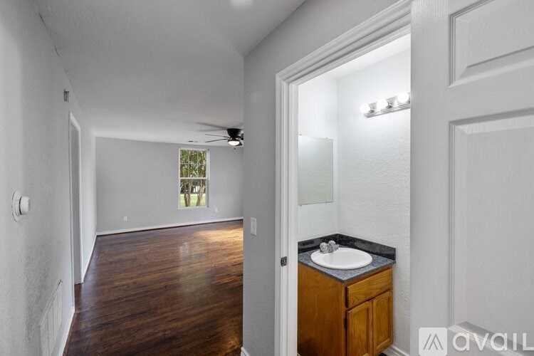 A bathroom with a wooden vanity and a window.