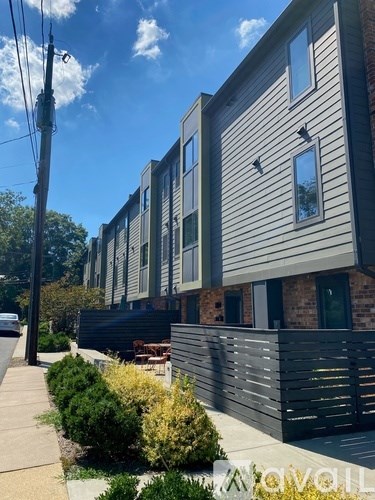 A modern building with a grey facade and a brick wall.