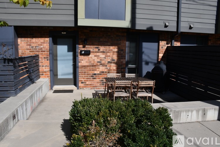 A patio with a table and chairs is in front of a brick building.