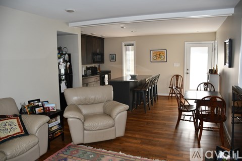 A living room with a brown leather chair and a dining table.