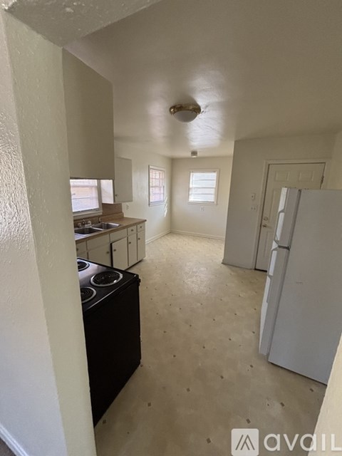 A kitchen with a black stove top oven and white cabinets.