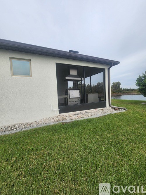 A modern house with a large glass window and a small garden in front.