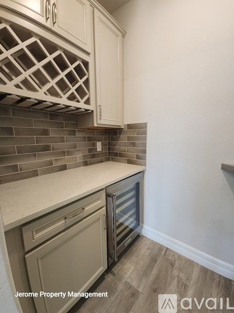 A kitchen with white cabinets and a brick backsplash.