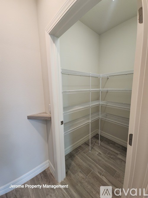A walk-in closet with shelves and a bench.