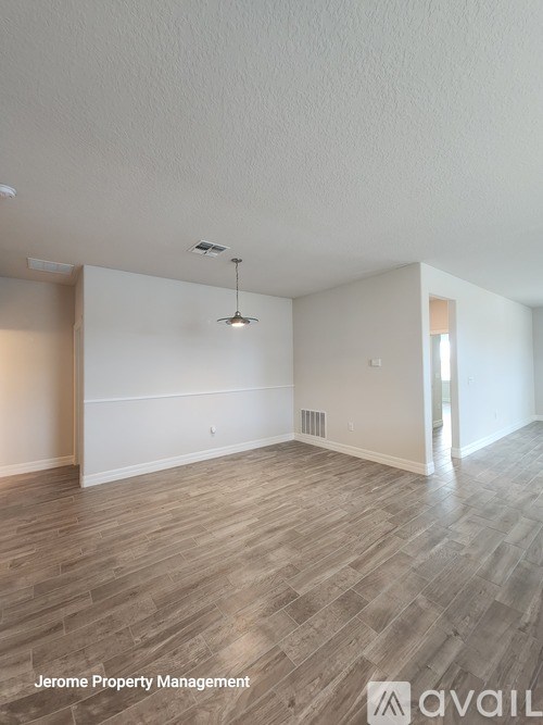 A room with wooden flooring and a ceiling fan.