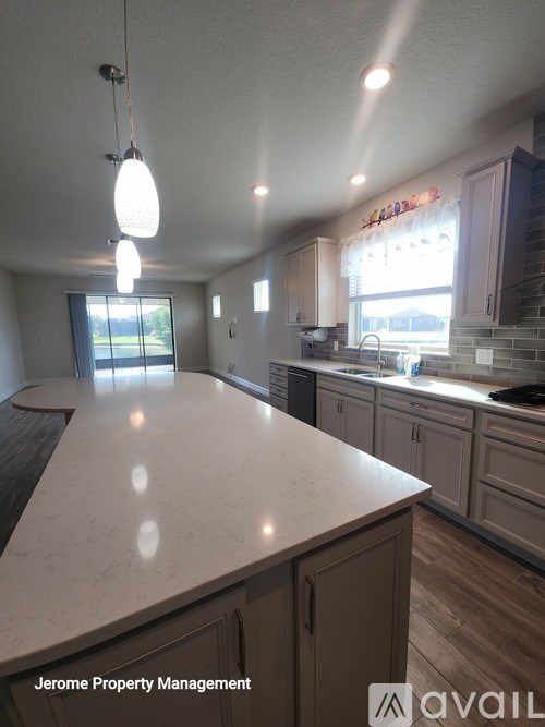 A kitchen with a marble countertop and wooden cabinets.