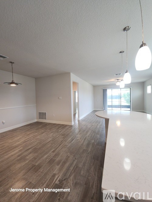 A spacious room with wooden flooring and a white countertop is available for rent.