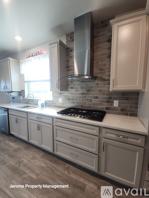A kitchen with a stove top oven and a range hood.