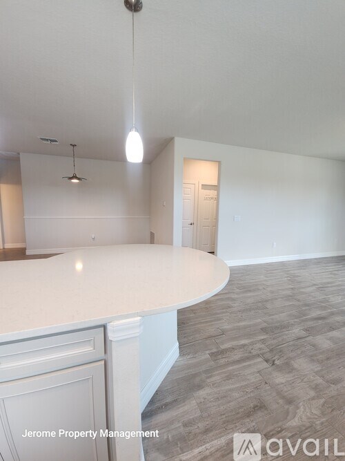 A white kitchen with a counter and a door in the background.