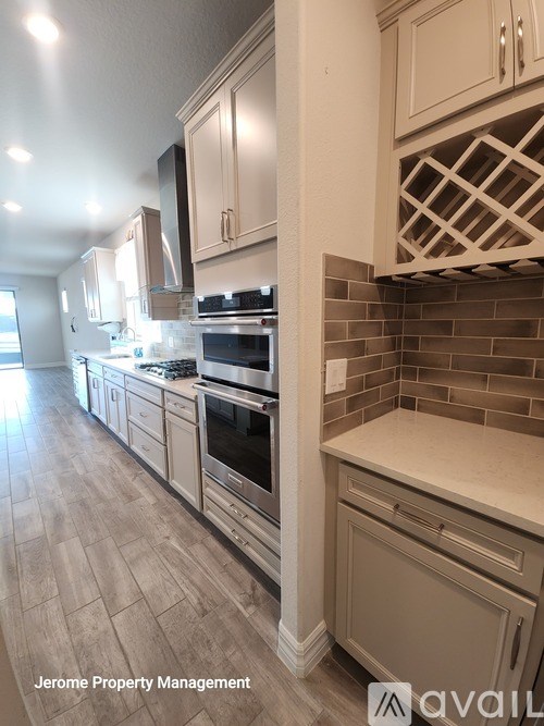 A kitchen with tile backsplash and wood flooring.