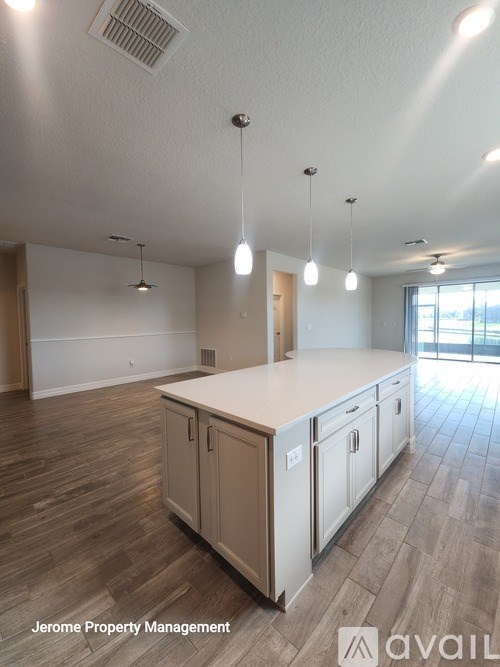 A kitchen area with wooden floors and a countertop.