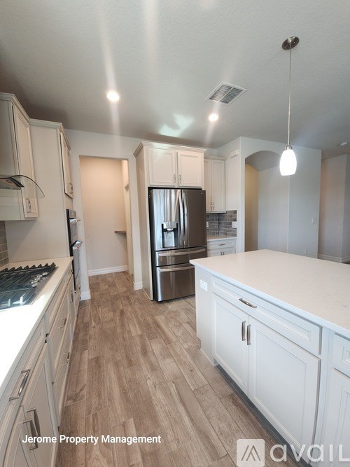 A kitchen with wooden floors and white cabinets.