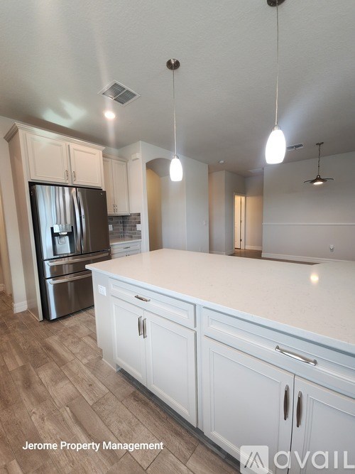 A kitchen with white cabinets and a wooden floor.