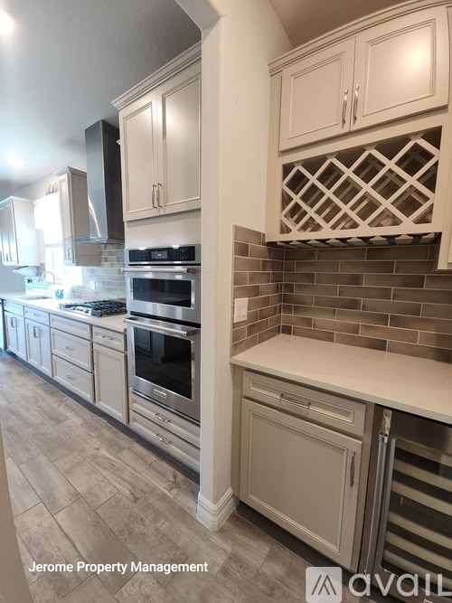 A kitchen with white cabinets and a tile backsplash.