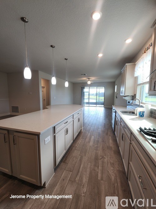 A kitchen with wooden floors and white cabinets.