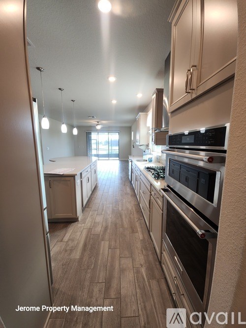 A kitchen with wood flooring and stainless steel appliances.
