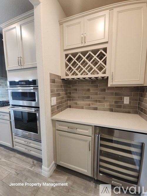 A kitchen with white cabinets and a tile backsplash.