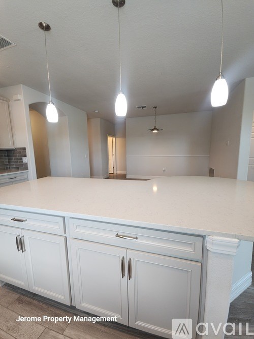 A kitchen with white cabinets and a countertop is shown.