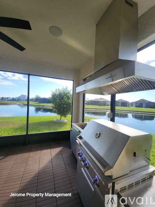 A grill is in a room with a window overlooking a lake.