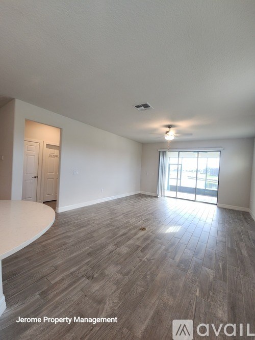 A room with wooden flooring and a large window is available for rent.