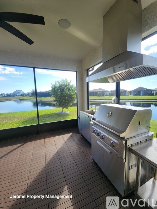 A kitchen with a large window overlooking a lake.