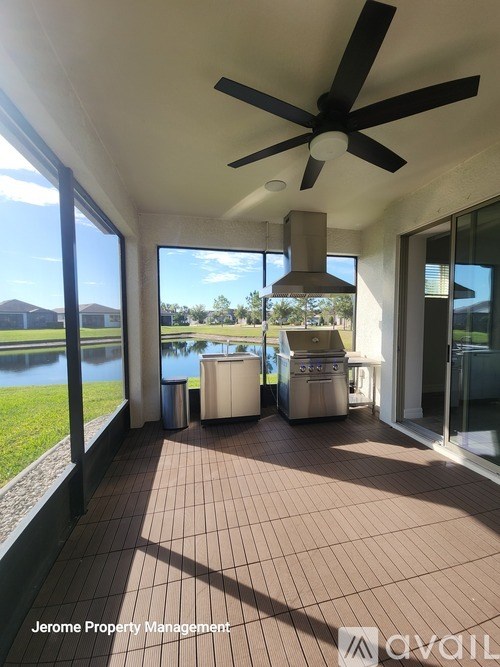A patio with a ceiling fan and a view of a body of water.