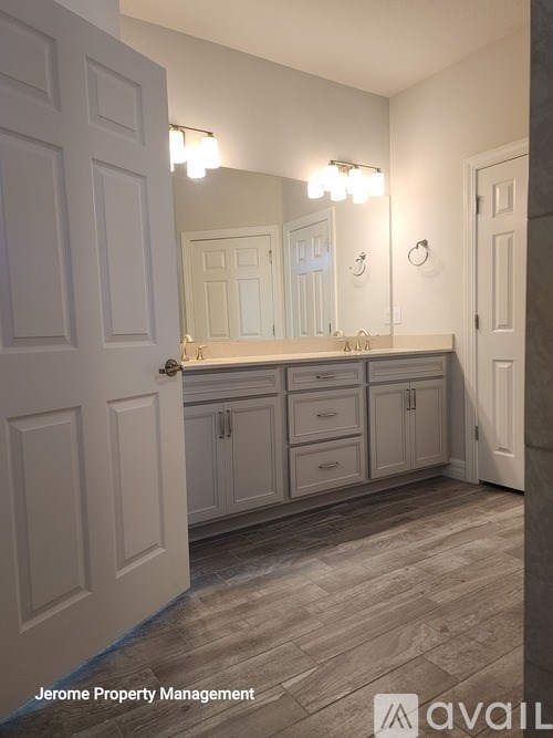 A bathroom with a vanity and a large mirror.
