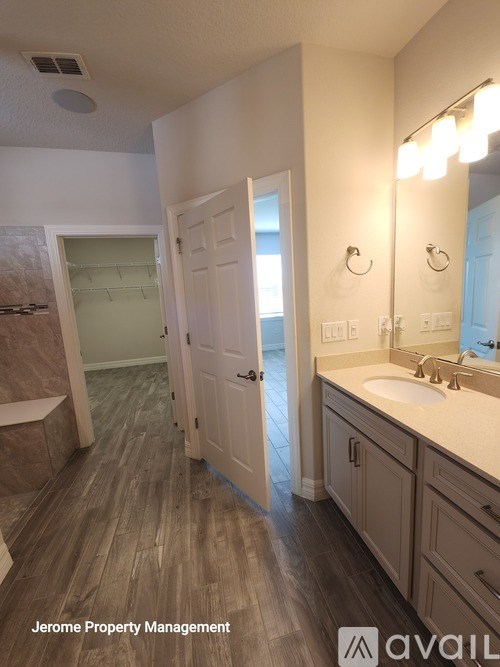 A bathroom with wooden floors and a white door.