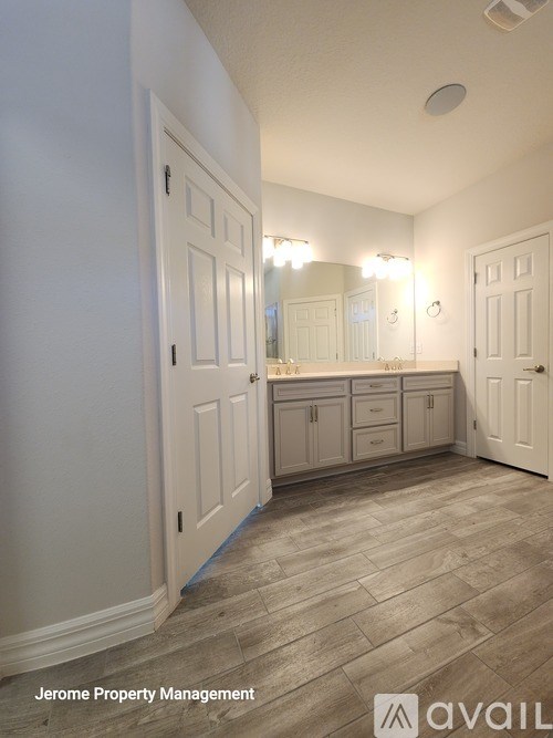A bathroom with a vanity and a large mirror.