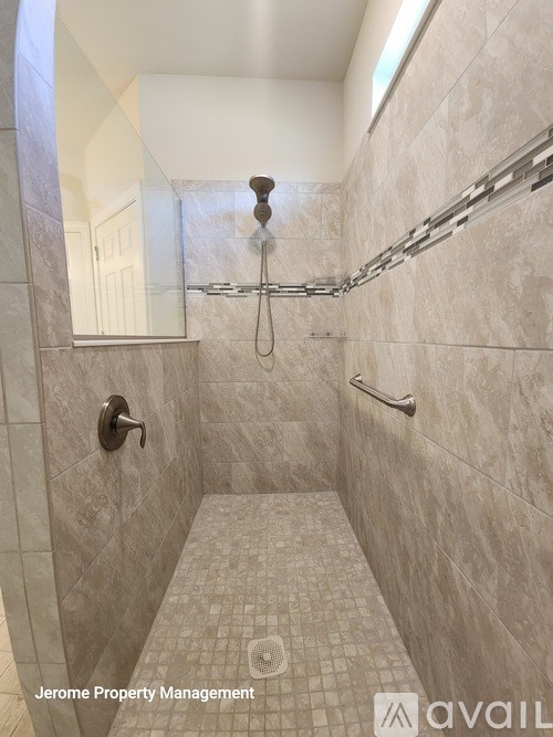 A tiled bathroom with Jerome Property Management written on the bottom.