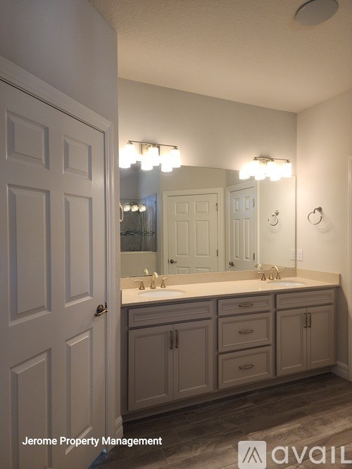 A bathroom with a vanity and a mirror above it.