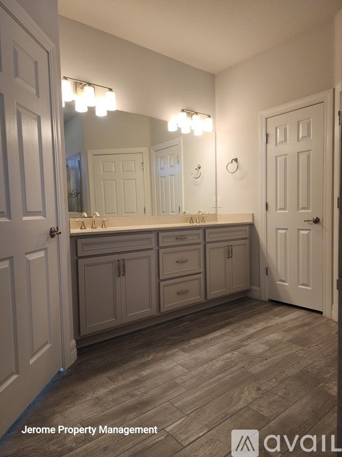 A bathroom with a vanity and a large mirror.