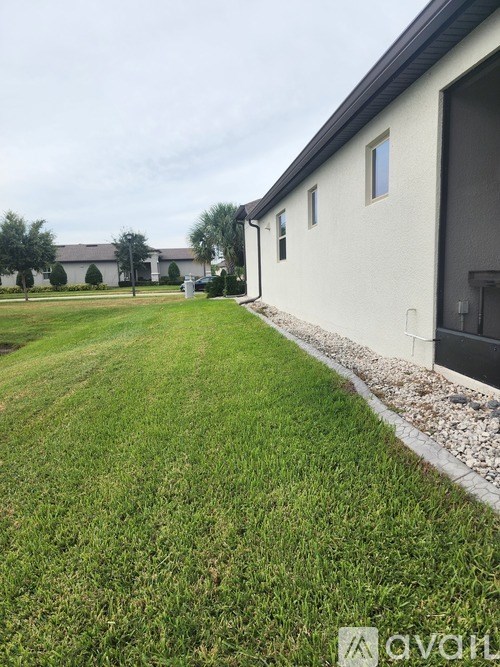 A grassy area in front of a building with a sign that reads "avail".