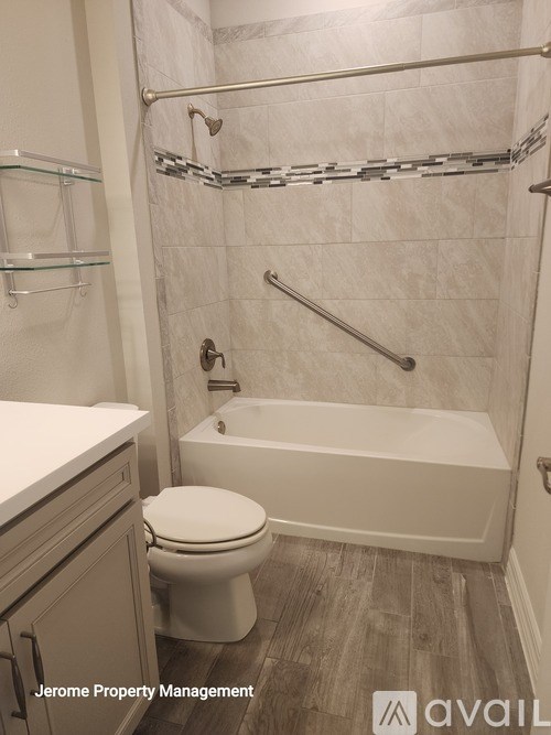 A white toilet sits next to a white bathtub in a bathroom.
