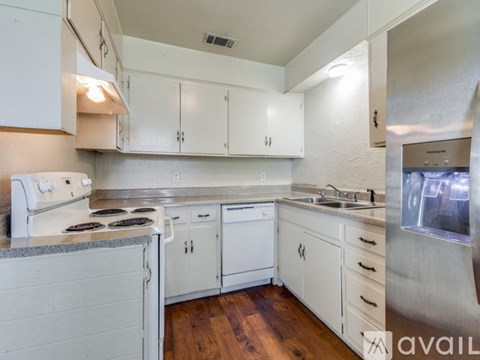 A kitchen with white cabinets and a stove top oven.