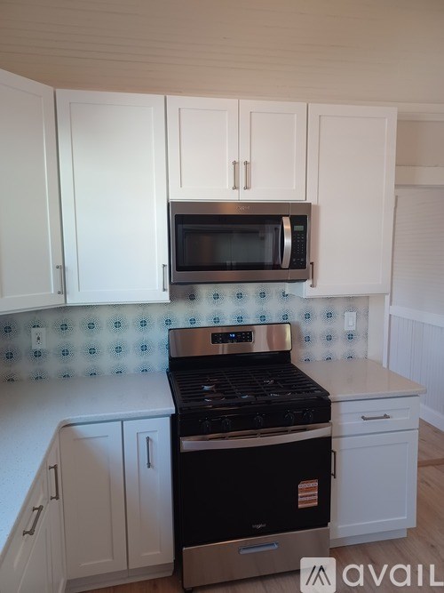 A kitchen with white cabinets and a black stove top oven.