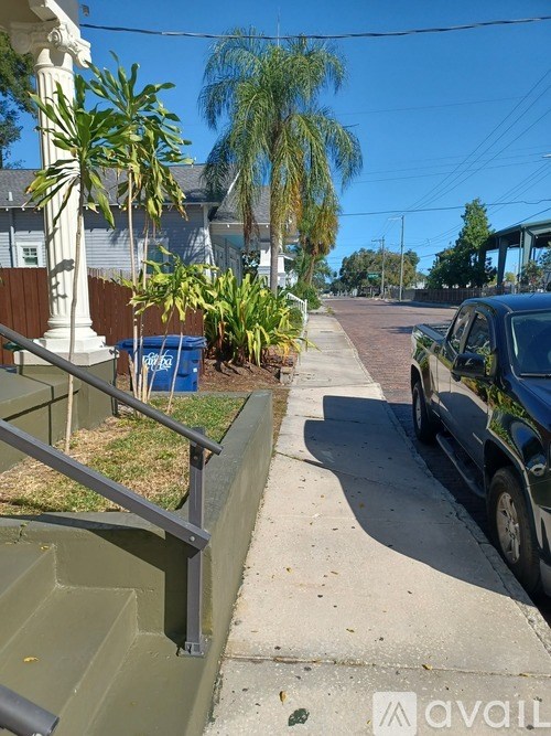 A black truck is parked on the side of a street.