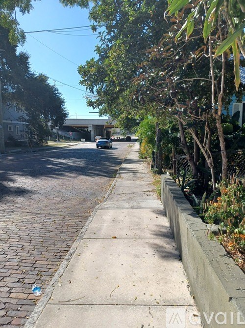 A tree-lined street with a car parked on the side.