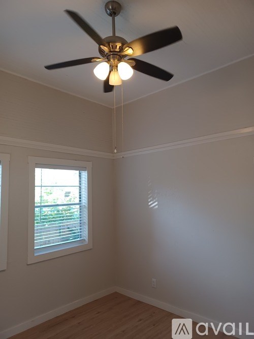 A room with a ceiling fan and a window.