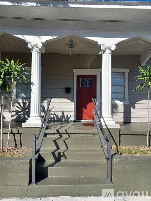 A house with a red door and a white porch.