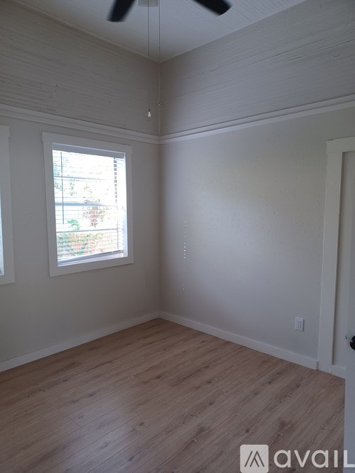 A room with a window and wooden flooring.