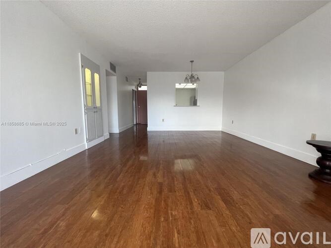 A room with wooden flooring and white walls.