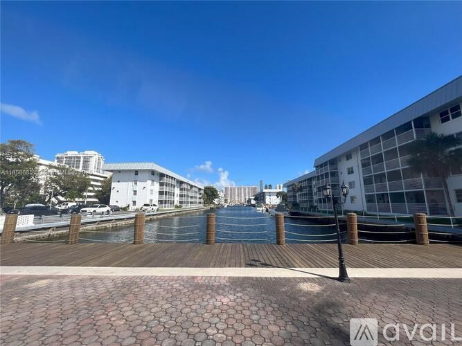 A cityscape with a clear blue sky and a body of water.