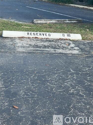 A white barrier with the word "RESERVED" on it is blocking off a parking spot.