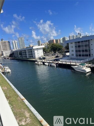 A view of a waterfront with boats docked and buildings in the background.