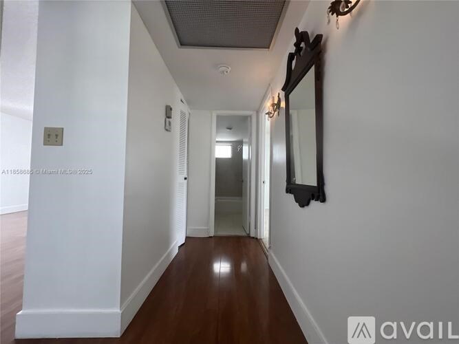 A long hallway with a mirror on the wall.